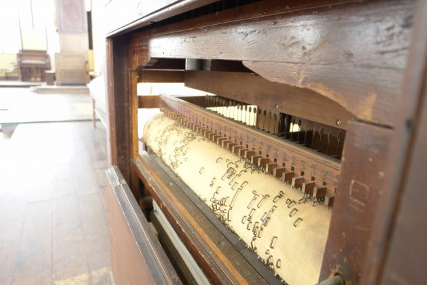 Photo en gros plan de l’orgue mécanique que Richard Coates construisit en 1820 pour la première salle de réunion des Enfants de la paix. Les pièces métalliques en saillie soulèvent des marteaux de bois qui produisent la musique dans une série de tuyaux. 