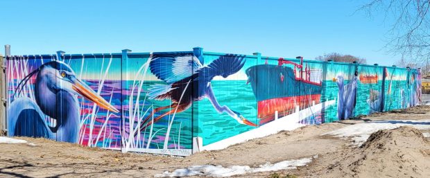 Photographie couleur d'une murale représentant des oiseaux et un grand navire.