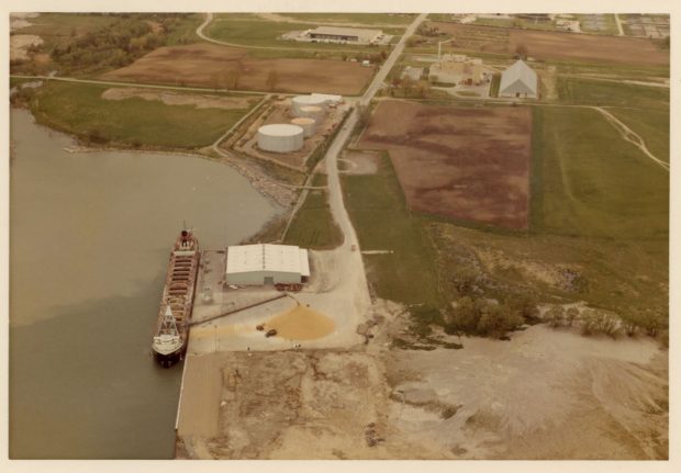 Photographie couleur d'un grand navire amarré au port déchargeant du sucre brut.