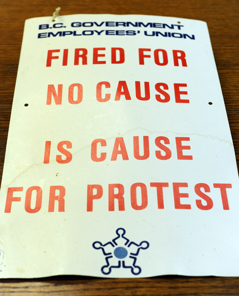 Une pancartes de grève indique « Union des employés du gouvernement de la Colombie-Britannique, Être congédié sans raison est une raison de protester » et comprend le logo de la BCGEU. 