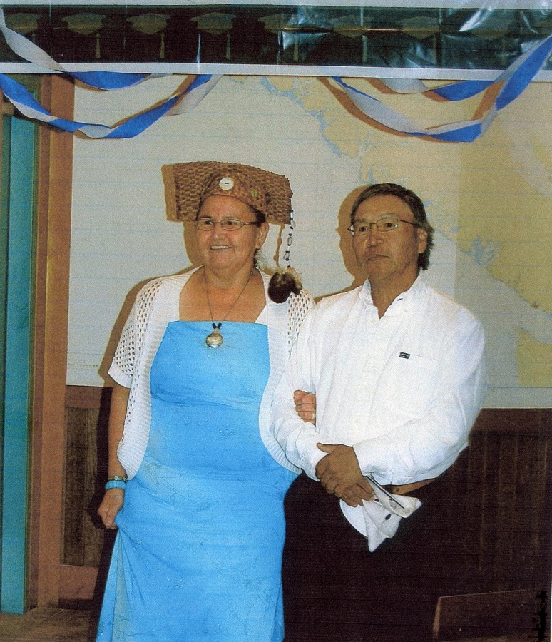 Un homme et une femme, côte à côte. La femme porte un chapeau de remise de diplôme fait d’écorce d’arbre tressée avec un « gland » en fourrure.