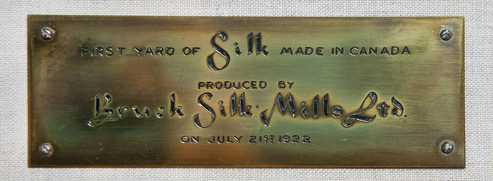 Plaque commémorative en laiton gravée avec l'inscription « First Yard of silk made in Canada »