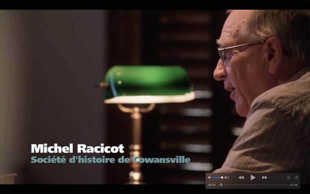 Profil d'un homme (Michel Racicot) regardant droit devant avec une lampe de table verte à  côté de lui.