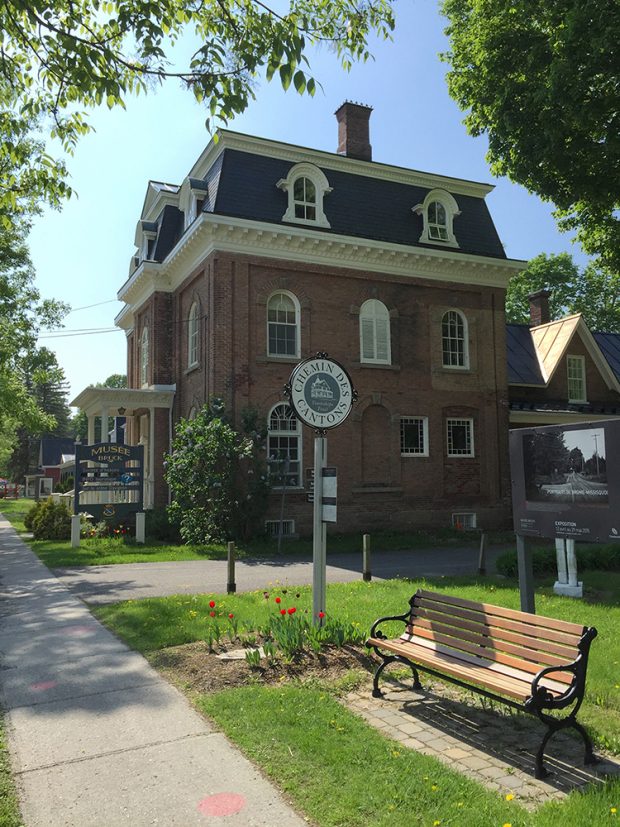 Photo du Musée Bruck avec banc de parc et enseigne à l’avant-plan