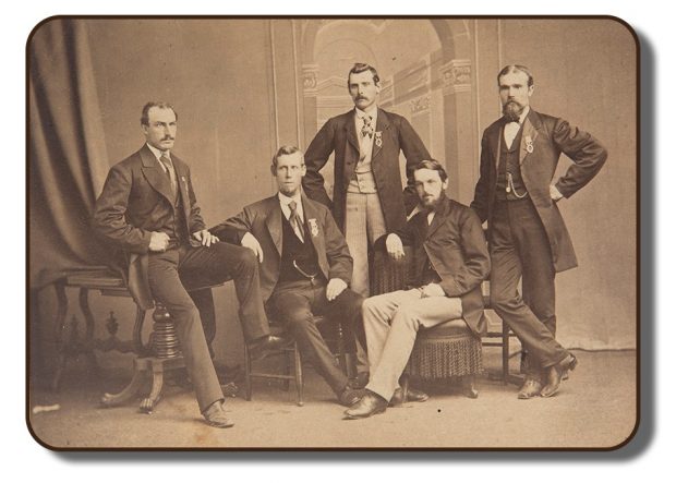 Photographie studio aux tons sépia des membres de l’équipage de Paris. Tous les quatre membres de l’équipage ainsi que leur gérant, Sherriff J. A. Harding, sont présents sur la photographie. Les hommes sont regroupés et sont assis sur différents meubles de l’époque. Ils portent tous un complet et une cravate puisque cette photographie a été prise dans le cadre des célébrations qui ont eu lieu à leur retour de Paris, en 1867.