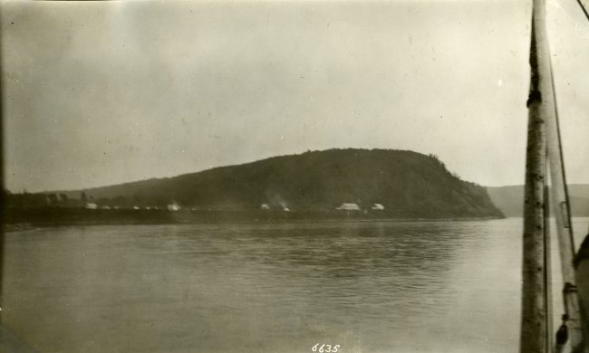 Photo en noir et blanc d'un terrain vallonné traversant une étendue d'eau.