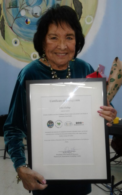 Photo en couleur de Lina Gallup âgée tenant un certificat en souriant.