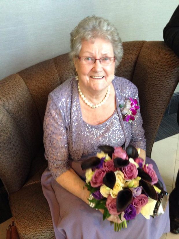 Une femme vêtue d’une robe habillée est assise un bouquet à la main