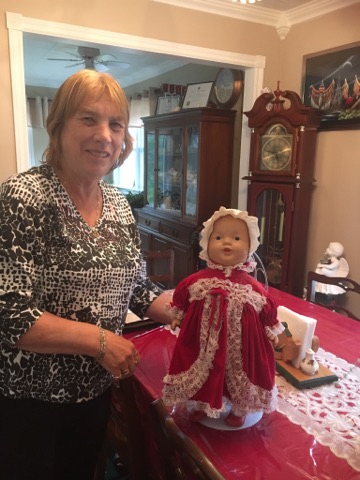 Ann Murphy avec une poupée en robe rouge. Elle a reçu cette poupée pour Noël, il y a plus de 70 ans 