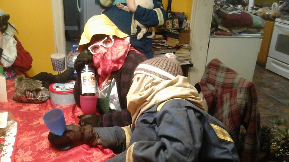 Deux personnes déguisées en mummers et le visage couvert sont assises à une table