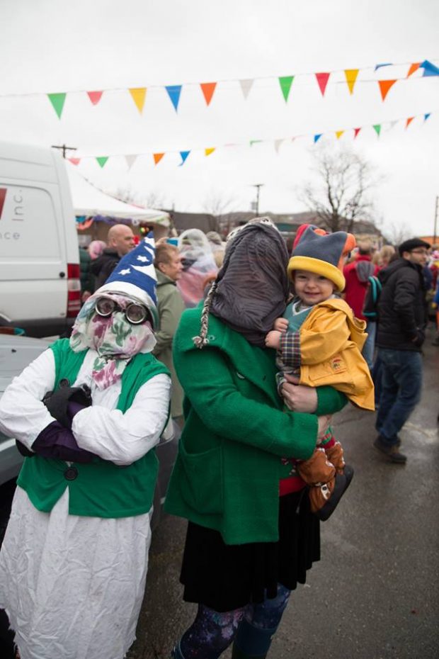 Deux mummers et un enfant défilent