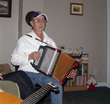 Un homme joue de l’accordéon lors d’une fête dans une maison.
