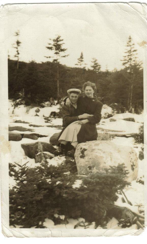 Un homme et une femme assis sur un rocher au milieu d’un ruisseau