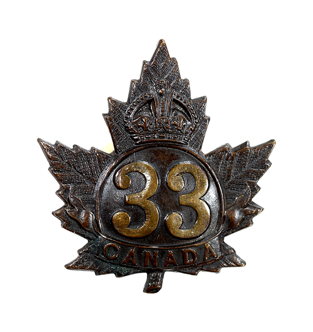 Un insigne en forme de feuille d’érable avec une couronne, le numéro 33 et le mot CANADA.
