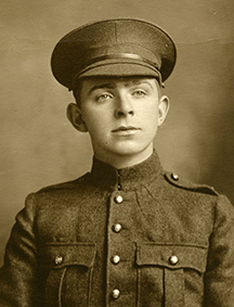 Portrait d’un soldat portant une casquette. On peut remarquer des poches poitrine, des boutons et des insignes de collet.