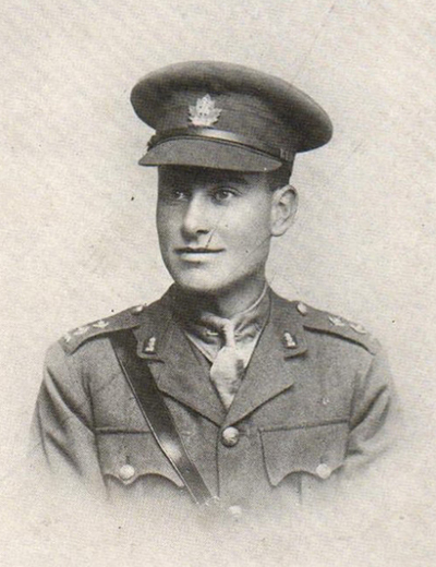 Portrait d’un soldat portant une casquette. Il a une moustache. On peut remarquer des poches poitrine, des boutons et des insignes de collet.
