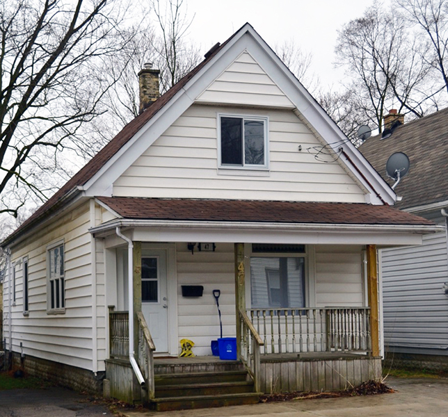 A 1 and 1/2 storey house, stairs to a porch, entry door on the right.