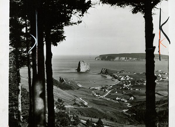 Photographie noir et blanc du Roché Percé. Il s’agit de l’un des points de vue les plus populaires. La photographie est prise en hauteur, a une distance éloignée du Rocher, ce qui donne une vue à la fois sur le village de Percé, l’Île de Bonaventure et le Rocher Percé. Les arbres des deux côtés de la photographies créent un cadre naturel autour de ce paysage.