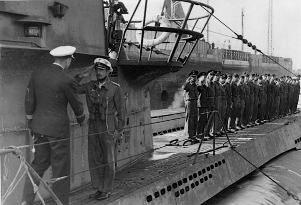 Le commandant du U-boot se tenant sur le pont du sous-marin salue un officier de la marine allemande