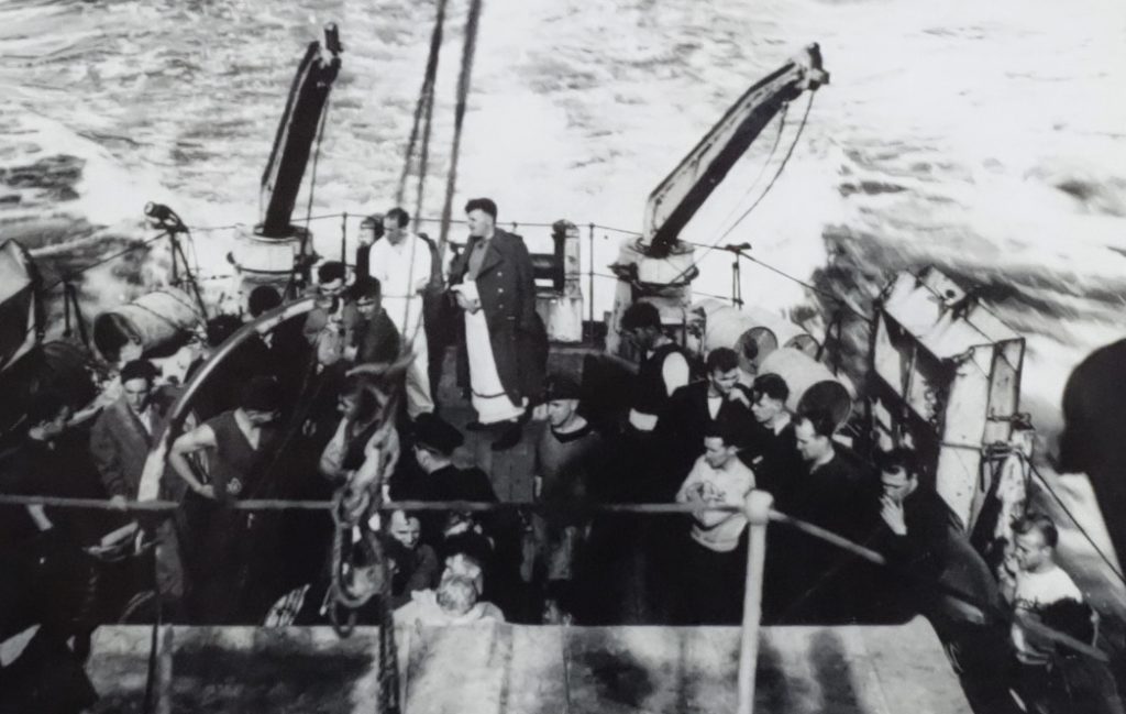 Un groupe d’hommes se tenant sur le pont arrière d’un navire de guerre