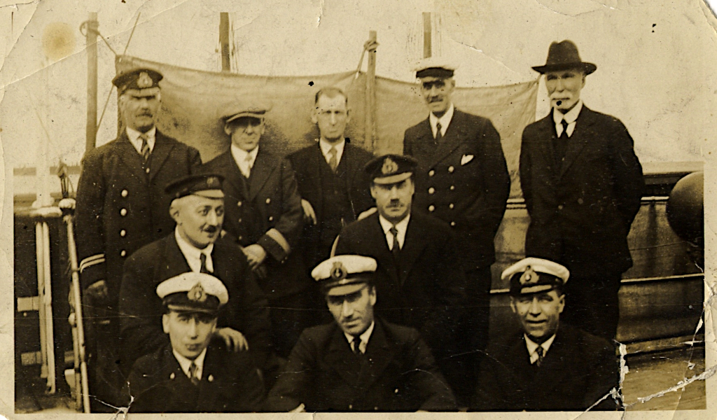 Un groupe d’hommes en uniforme de la marine ou en civil