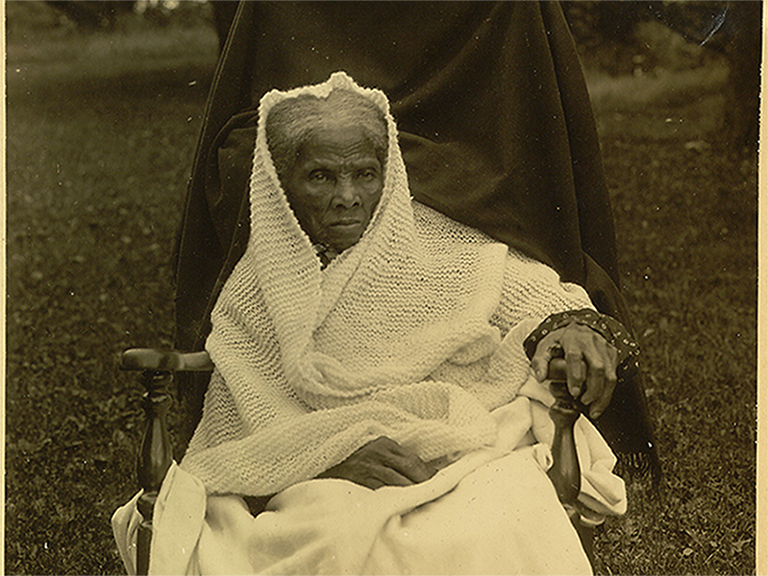 Portrait historique de Harriet Tubman dans ses dernières années, drapée dans un châle blanc, reflétant son héritage en tant qu'humanitaire et chef de file communautaire.