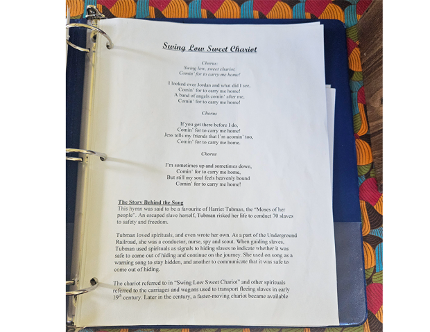 Page d'un recueil de chansons montrant les paroles de 'Swing Low Sweet Chariot' et le contexte historique sur Harriet Tubman et le chemin de fer clandestin.