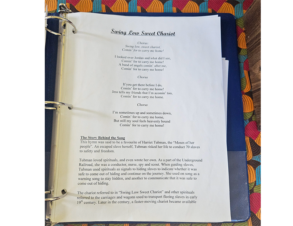 Page d'un recueil de chansons montrant les paroles de 'Swing Low Sweet Chariot' et le contexte historique sur Harriet Tubman et le chemin de fer clandestin.