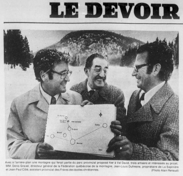 Extrait du journal Le Devoir montrant 3 hommes tenant ensemble le plan du projet de parc à Val-David.