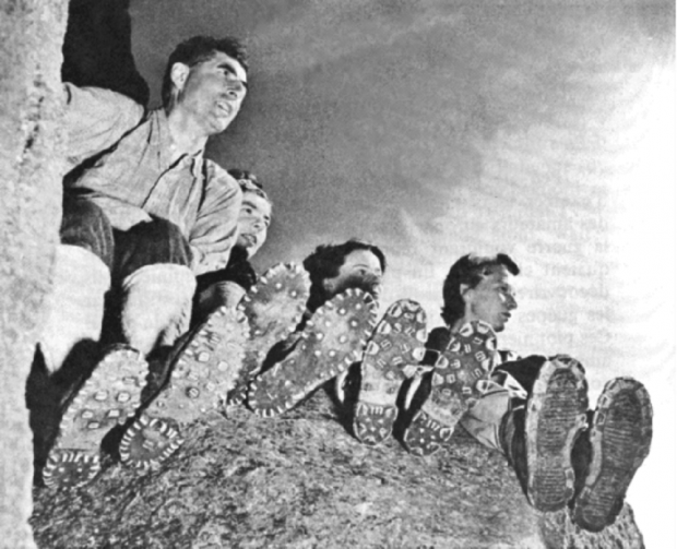 Quatre personnes assises sur le sommet d’un rocher.