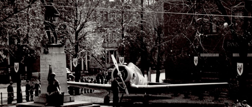 Parc public avec une statue de soldat et un avion militaire.