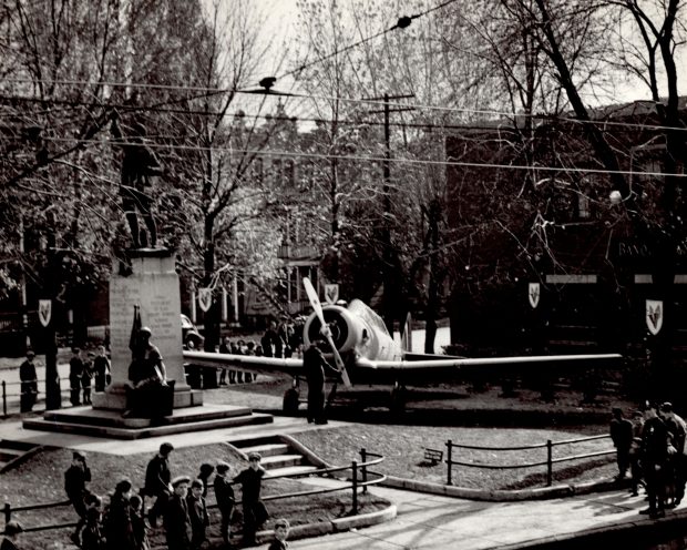 Parc public avec une statue de soldat et un avion militaire.