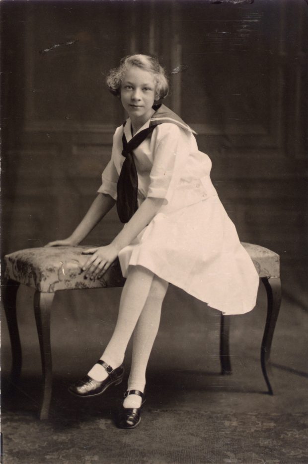 Portrait en noir et blanc d’une jeune femme assise sur un banc.