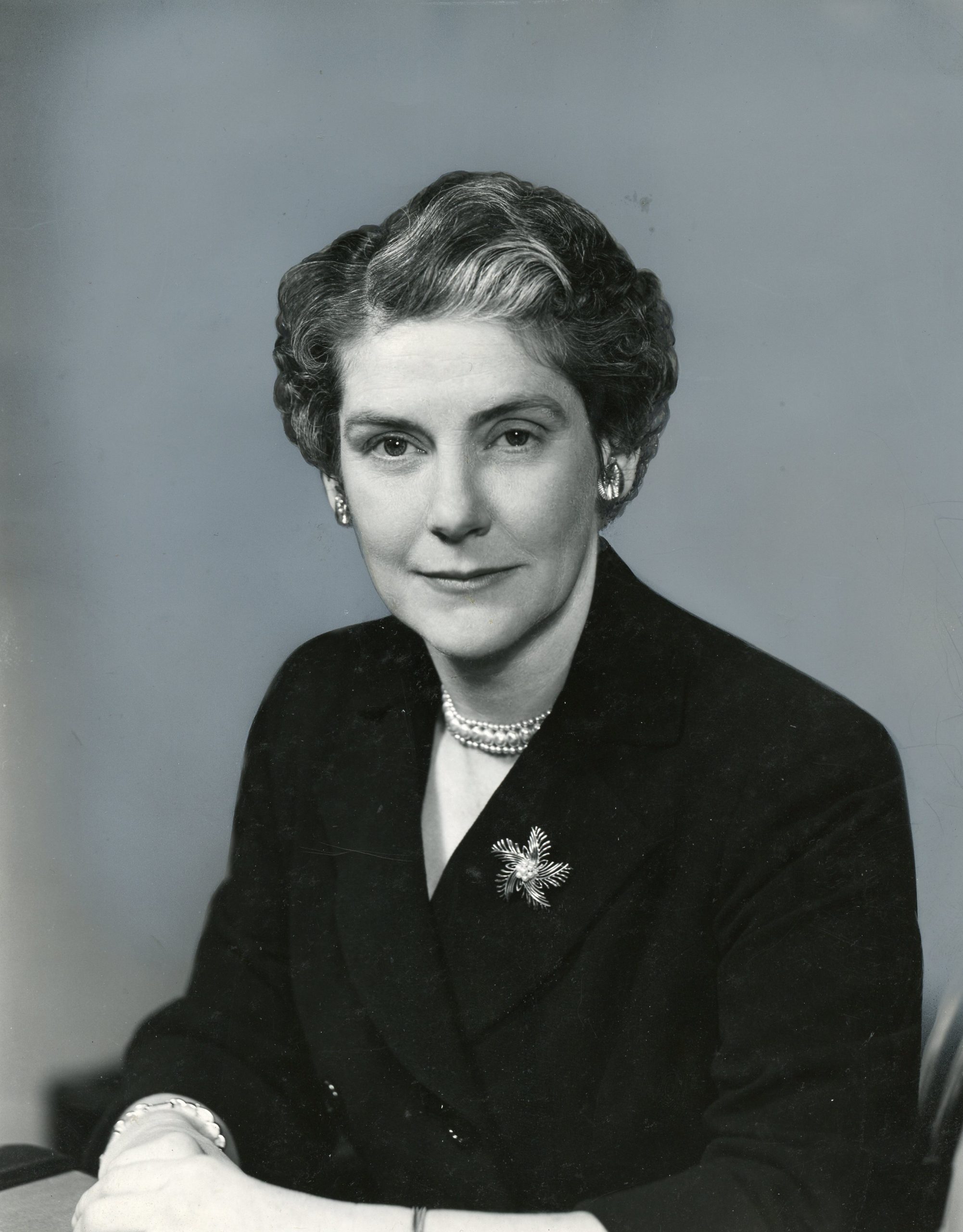 Portrait en noir et blanc d’une femme d’âge mûr, vêtue d’un blazer.