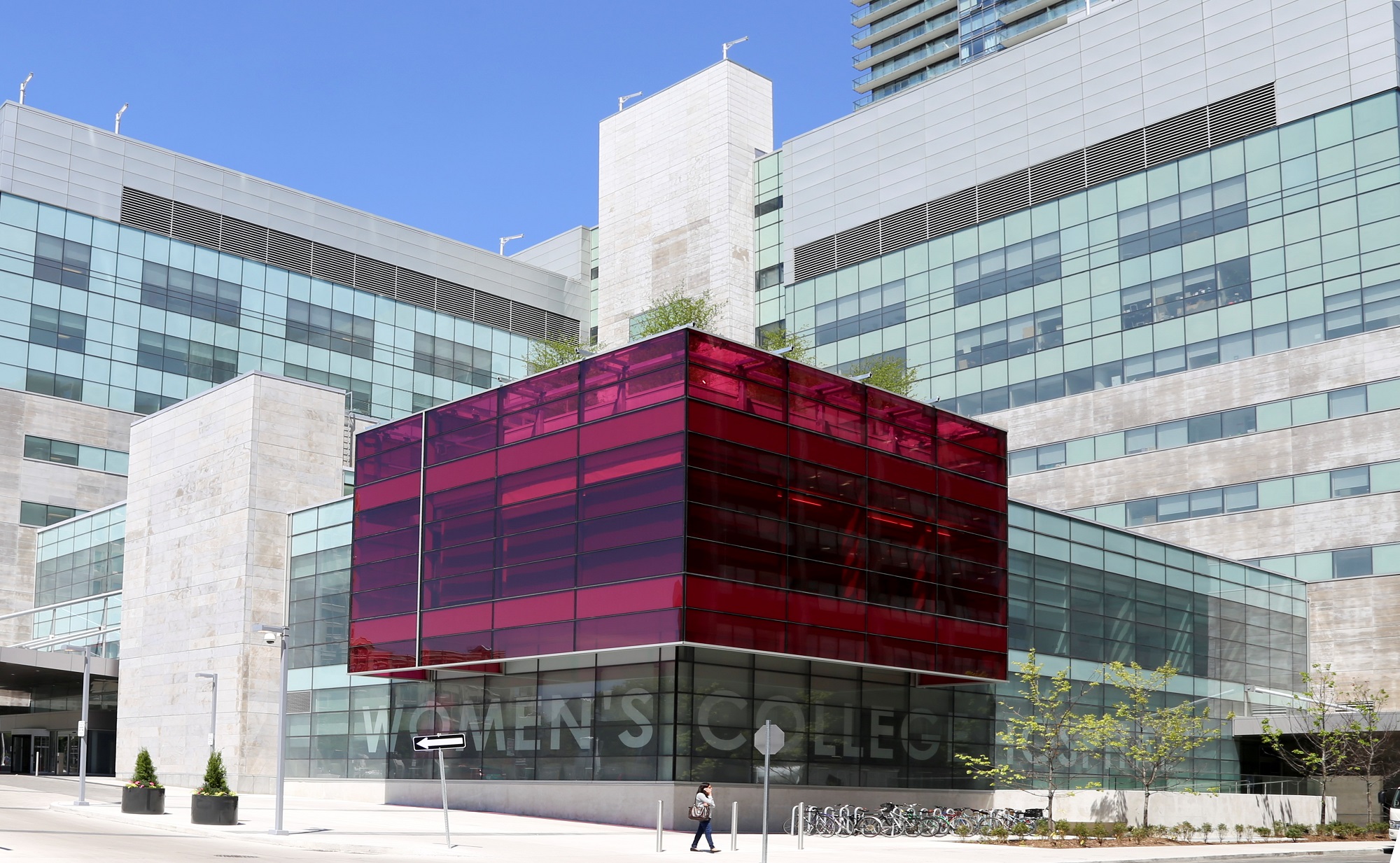 Une photo en couleur de l’extérieur du Women's College Hospital; l’immeuble est orné d’un grand cube rose en verre.