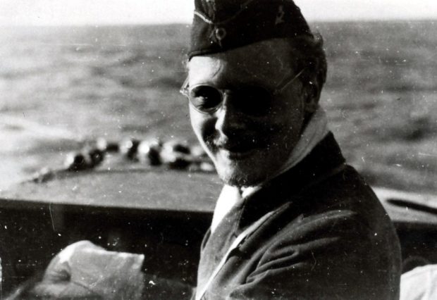 Portrait non officiel d’un commandant de sous-marin souriant, portant un uniforme et des lunettes de soleil