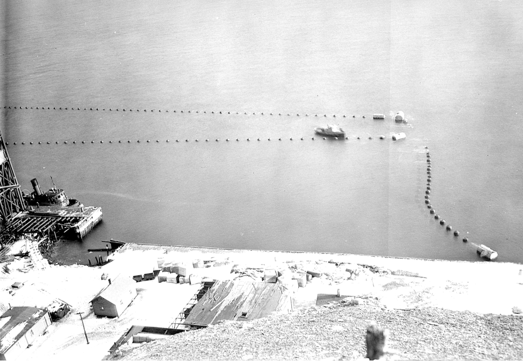 Photo montrant le quai de chargement du minerai sur Bell Island, entouré d’un filet anti-torpilles