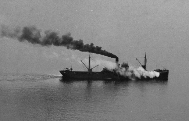 Navire à vapeur en mer avec un panache noir de fumée de charbon sortant de la cheminée