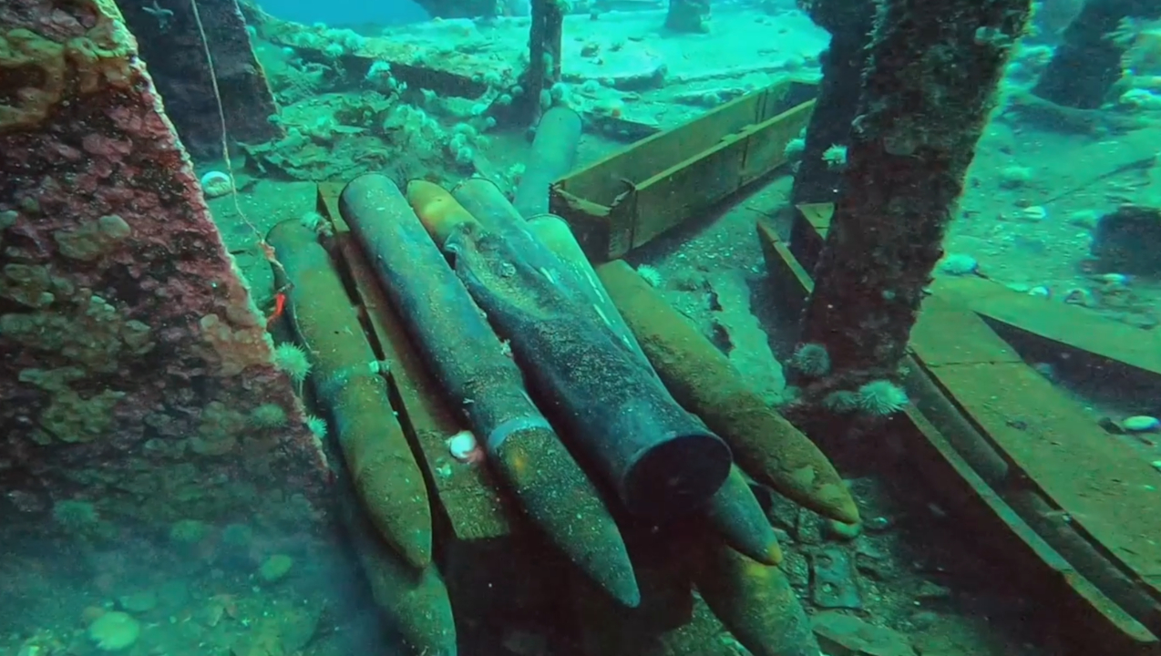 une douzaine d’obus d’artillerie sur le pont d’une épave submergée