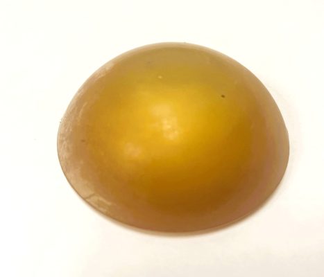 Objet brun lisse de forme voûtée sur un fond blanc.