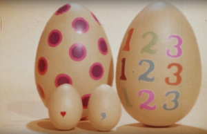 Quatre œufs décorés, dont deux gros avec motifs et deux petits avec symboles.
