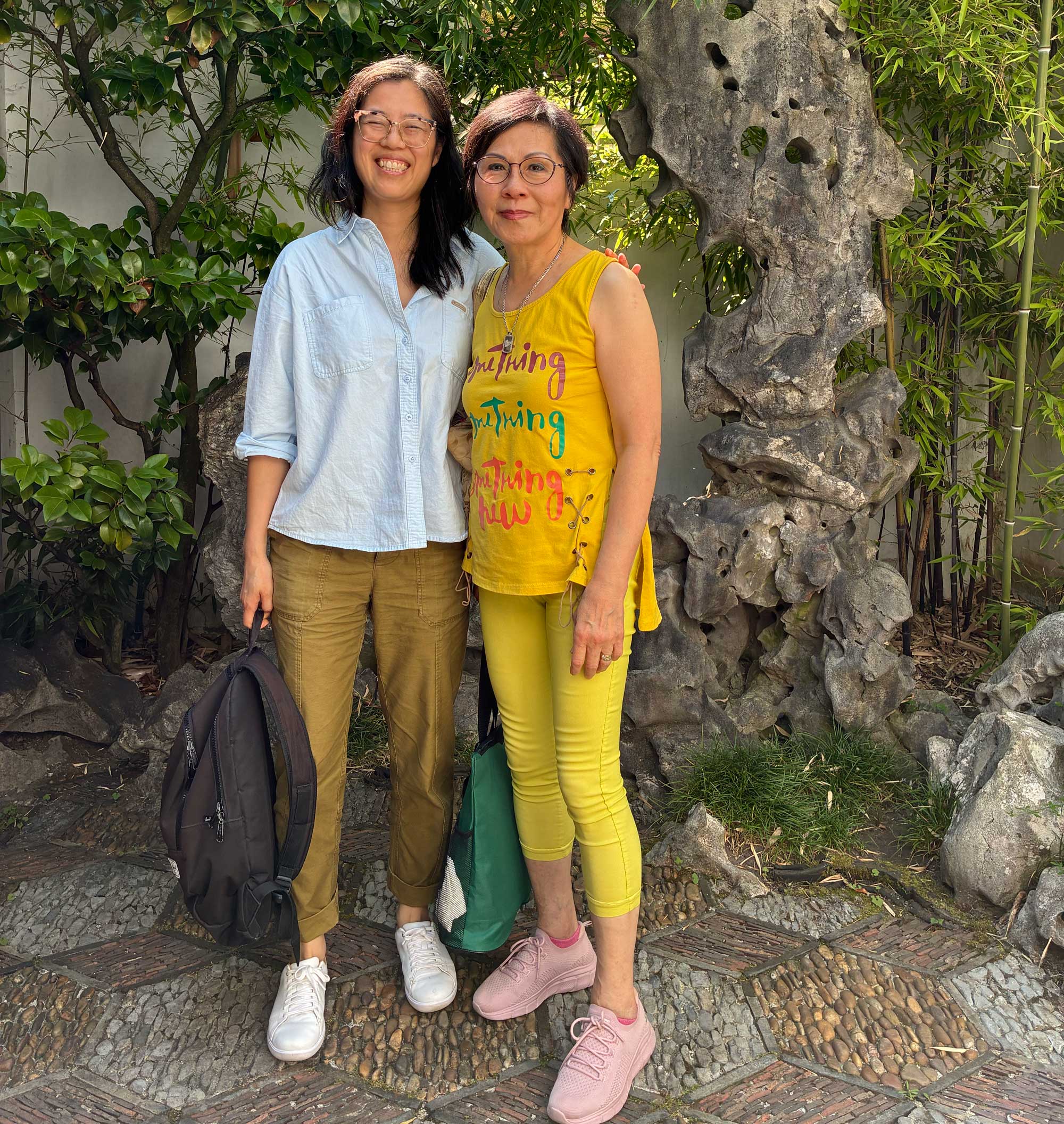 <span style="font-weight: 400;">Karen Tam et Rosa Cheng se tiennent debout à l’extérieur, les bras l’une autour de l’autre. Tout sourire, Karen a les yeux fermés.</span>