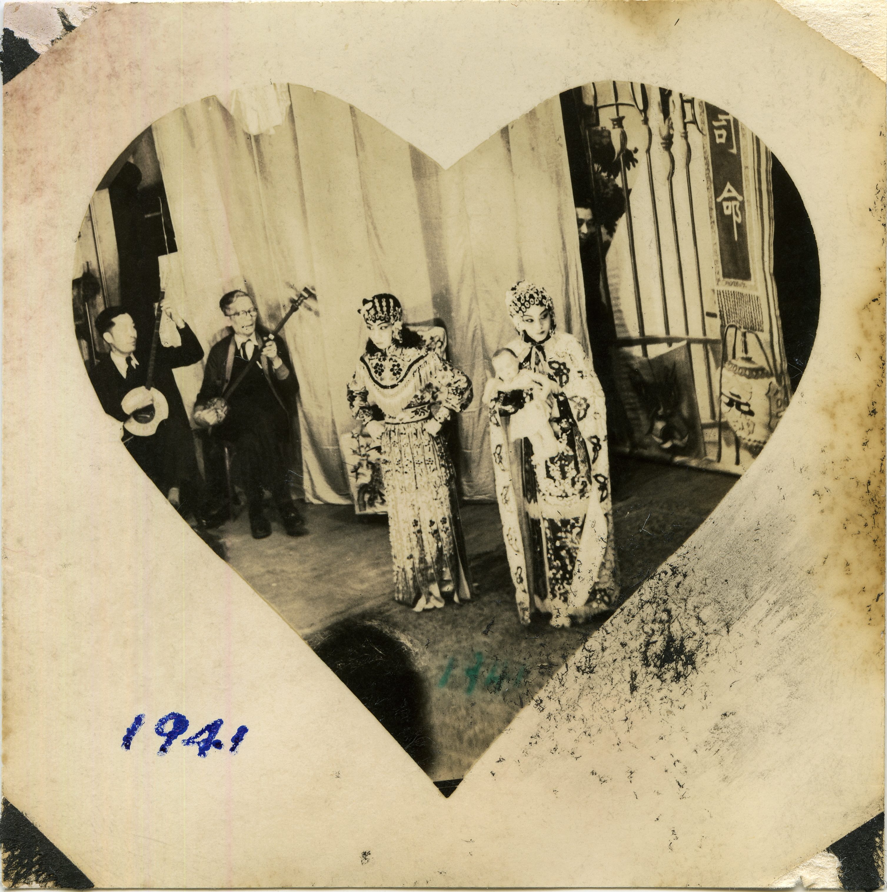 <span style="font-weight: 400;">Photo en plongée à l’intérieur d’un cadre en forme de cœur de deux membres en costume de la troupe d’opéra.</span>