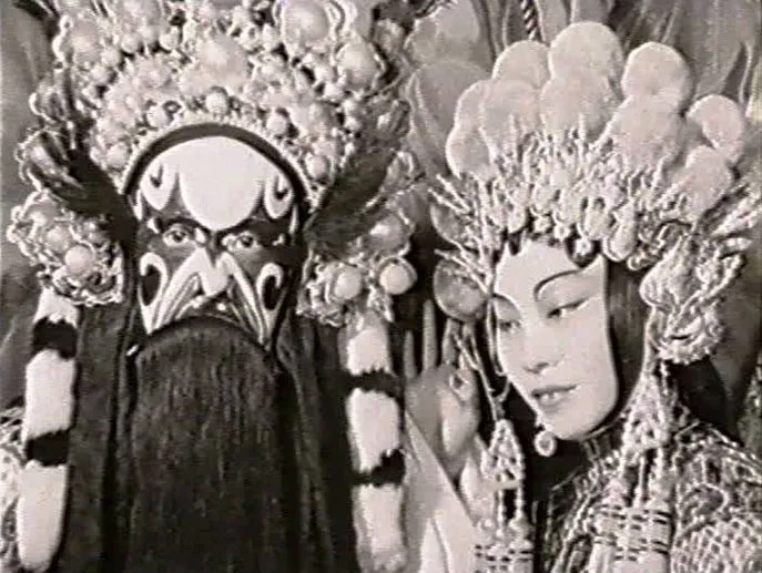 <span style="font-weight: 400;">Black-and-white close-up of two performers in very ornate costumes. </span>