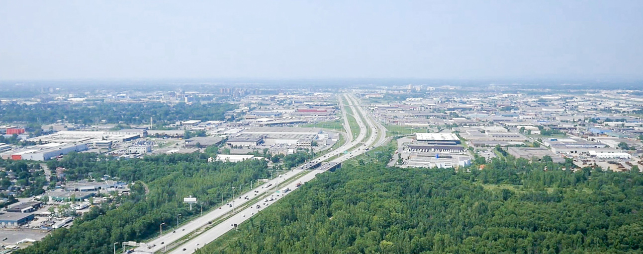 Photographie aérienne en couleur. Vue sur l’autoroute Jean-Noël Lavoie et le secteur industriel de Laval.