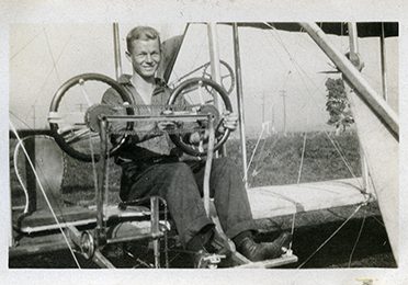 Un homme assis aux commandes d'un biplan d’entraînement.